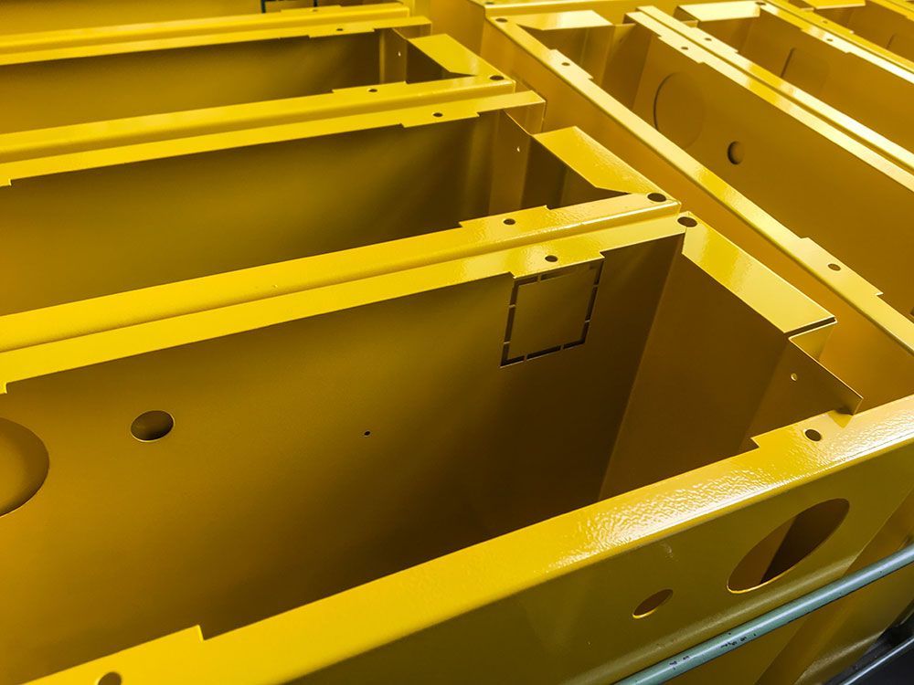 Gelb lackierte Metallboxen mit Löchern darin