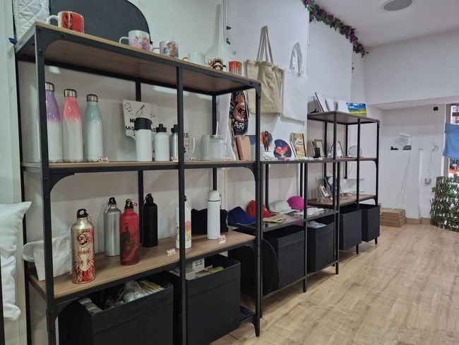 Una fila de estantes llenos de botellas y tazas en una tienda.