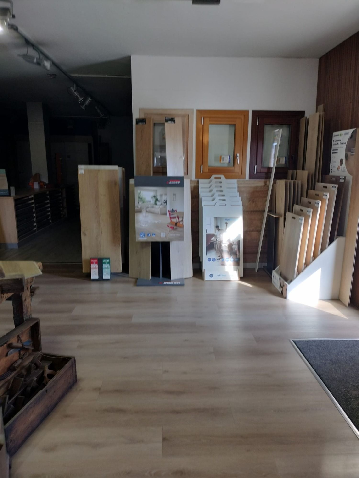 Interior de la sala de exposición con paneles de exhibición, espejos y muestras de pisos a lo largo de una pared 