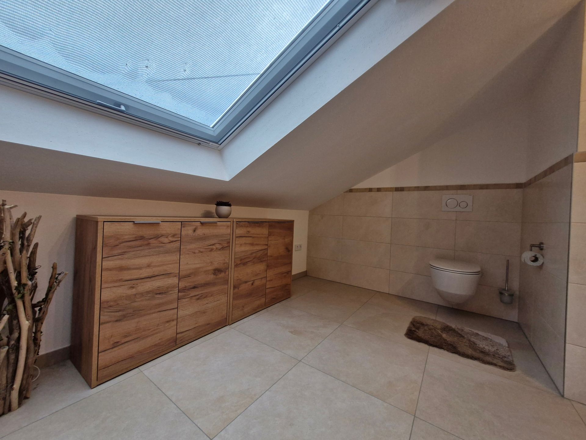 Helles Badezimmer mit Dusche, Waschbecken und Toilette.