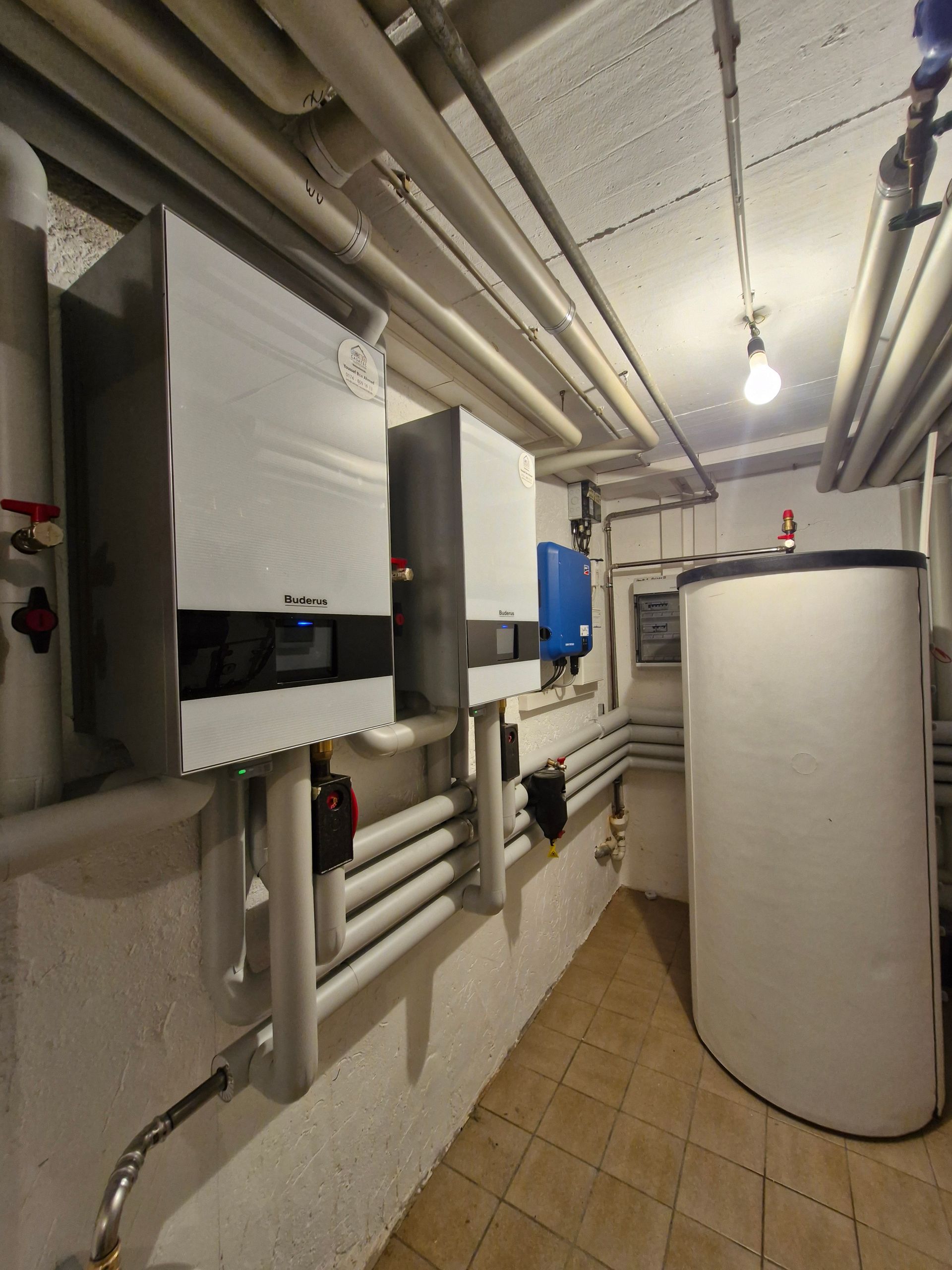 Solaranlage und Windräder auf einer grünen Wiese unter blauem Himmel mit Wolken