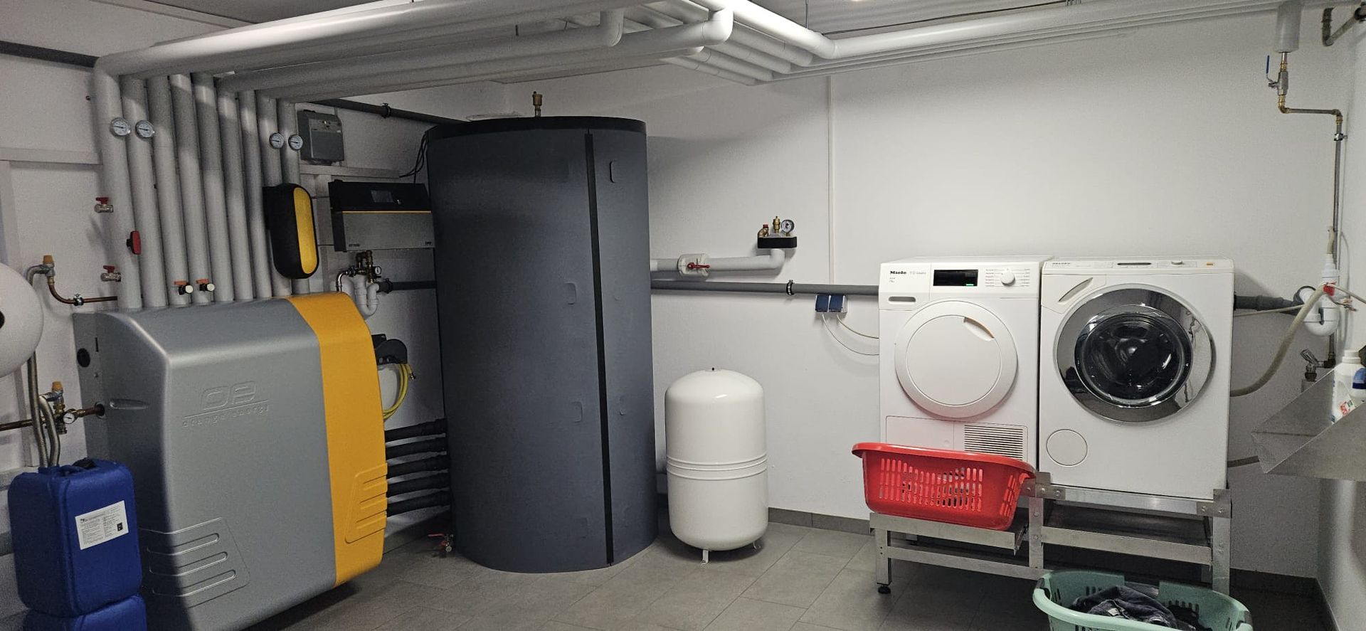 Hand stellt digitale Heizungssteuerung an der Wand ein.