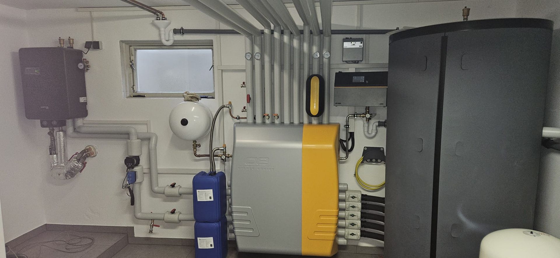 Weißer Designheizkörper vor grauer Wand.