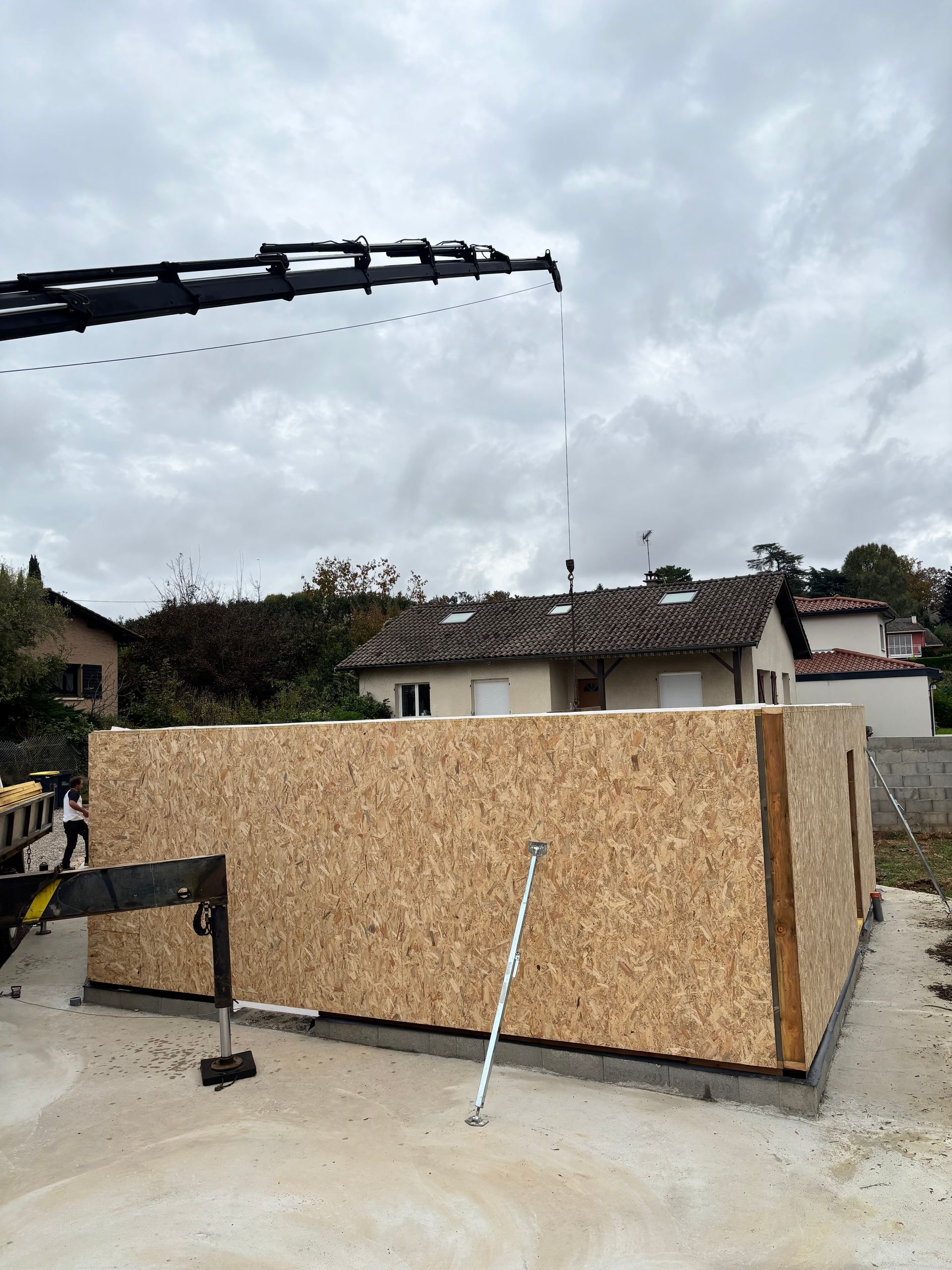 Pose de panneaux OSB avec une grue