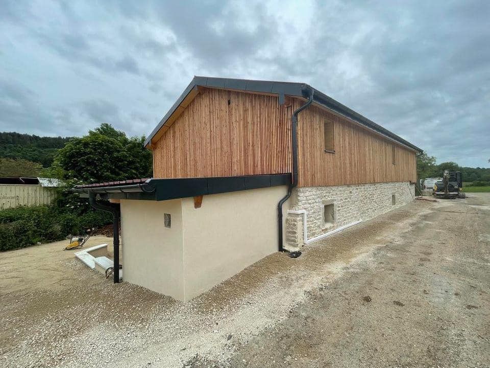 Maison en bois avec un bardage en bois et en pierre