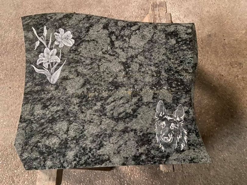 Carreaux de pierre mouchetée foncée avec de petites incrustations florales blanches sur une surface beige