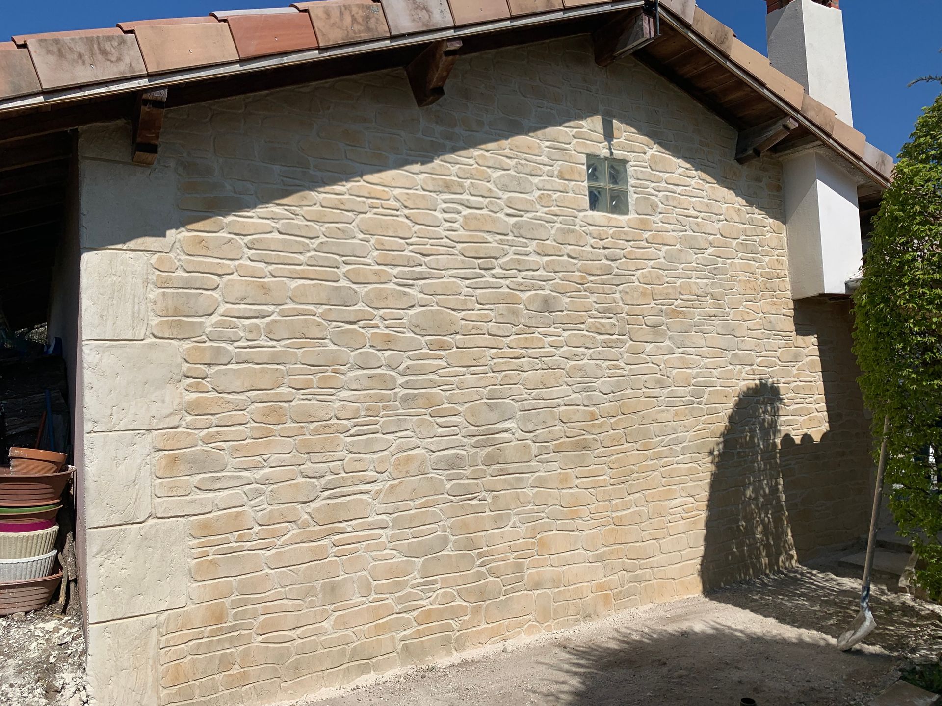 Zoom sur la main d'un homme qui applique un enduit décoratif de couleur verte