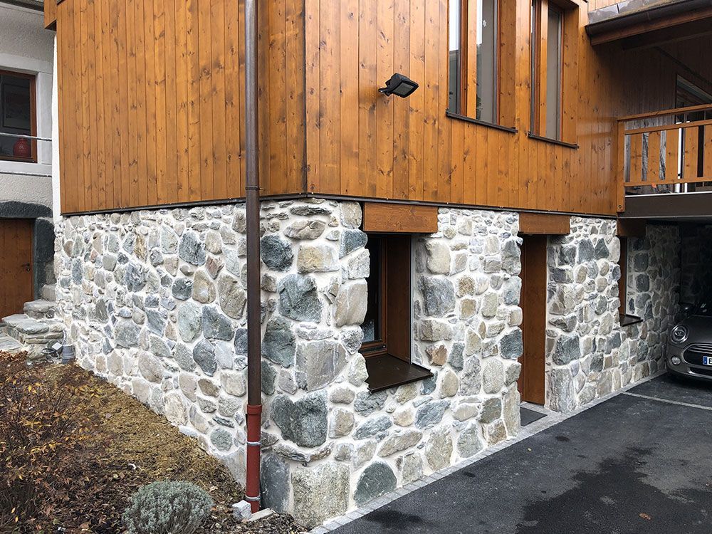 Maison avec des murs en pierre et un bardage en bois