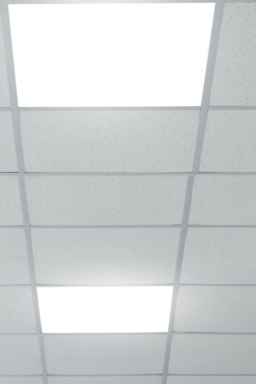 Plafond blanc avec spots rectangulaires encastrés et une grille de dalles de plafond.