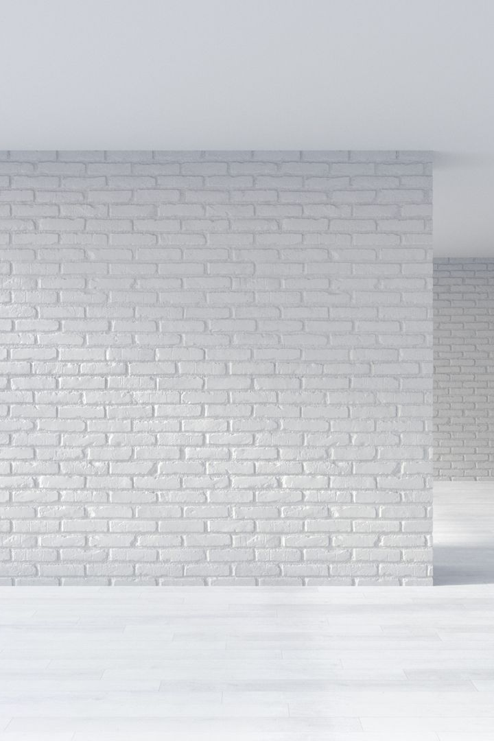 Mur de briques blanches dans une pièce vide et lumineuse, avec sol et plafond blancs.