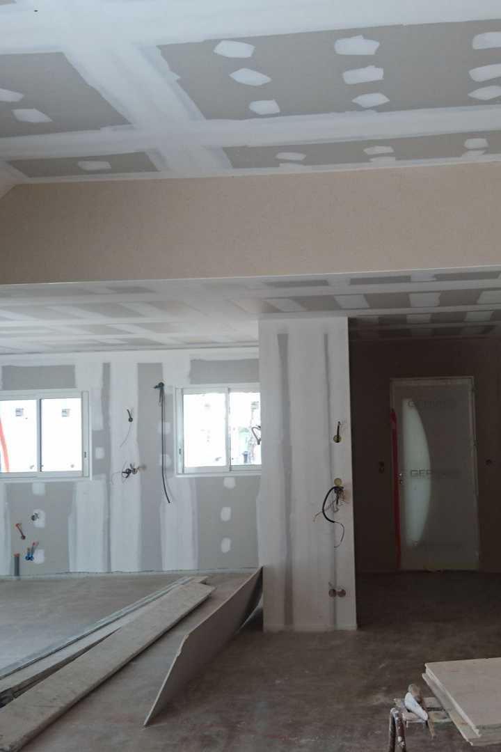 Intérieur en cours de construction, avec des plaques de plâtre installées sur les murs et le plafond.