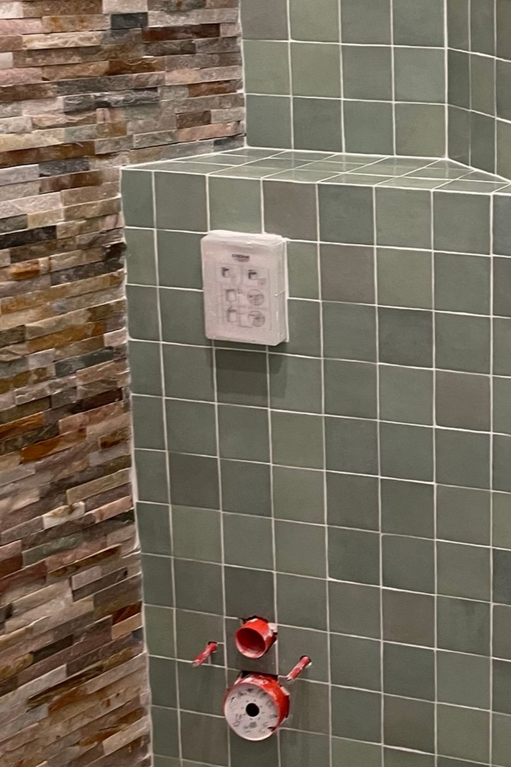 Mur carrelé de carreaux carrés gris.