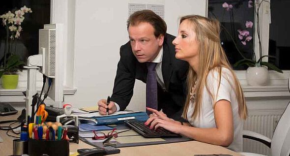 Dr. Brinkmeier erklärt einer Frau etwas am Computer