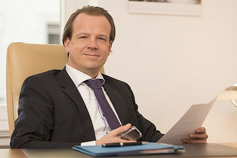 Dr. Brinkmann sitzt am Schreibtisch