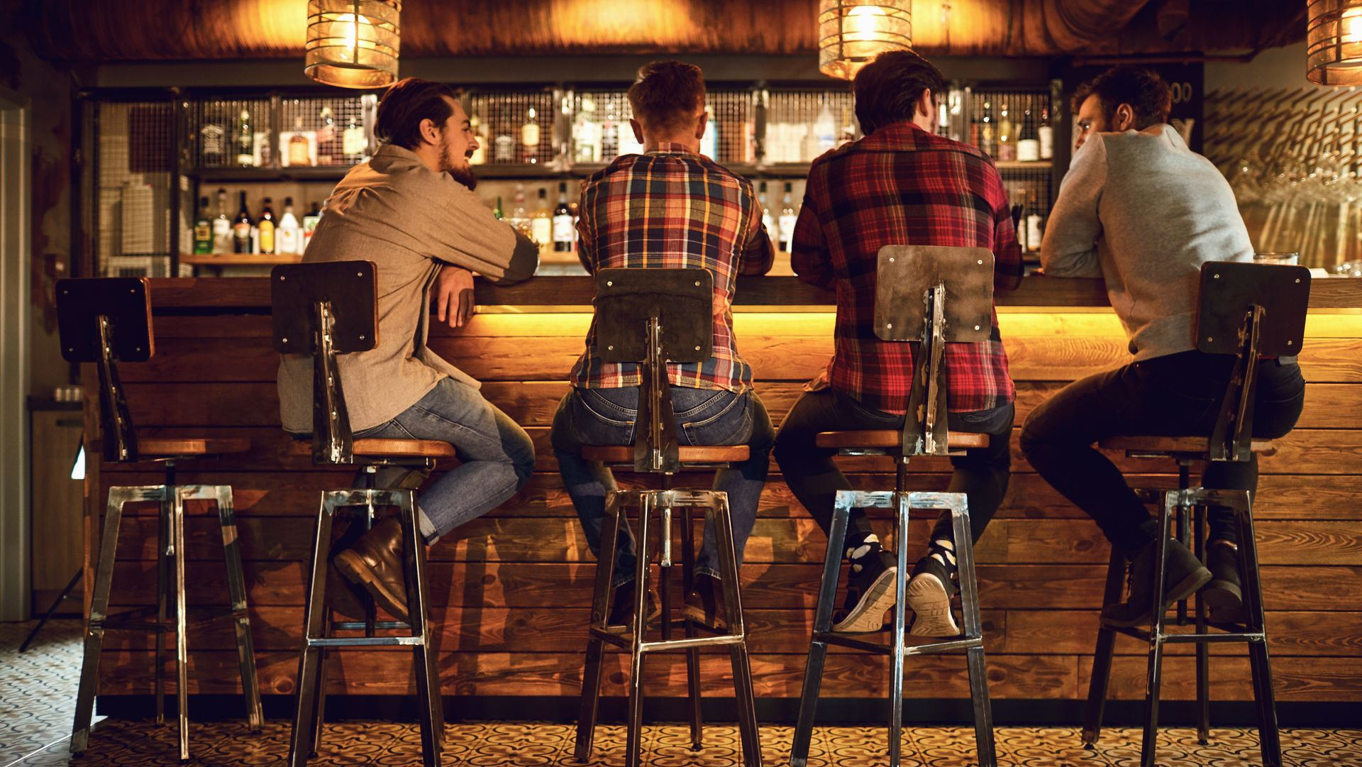 Quatre personnes sont assises à un bar et discutent.