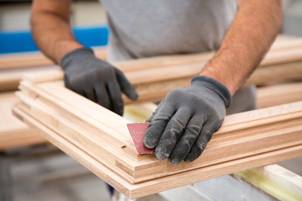 Professionnel ponçant un cadre de fenêtre en bois