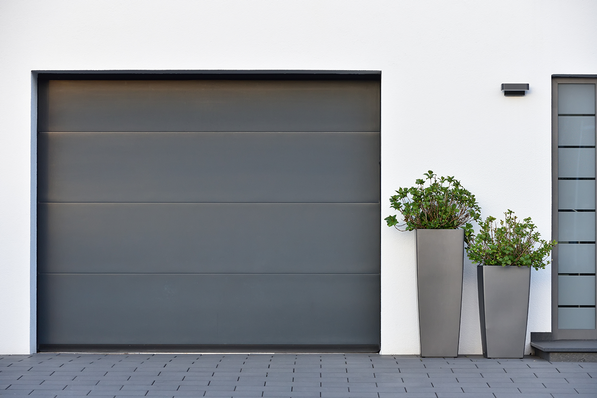 Porte de garage anthracite avec des pots de plantes