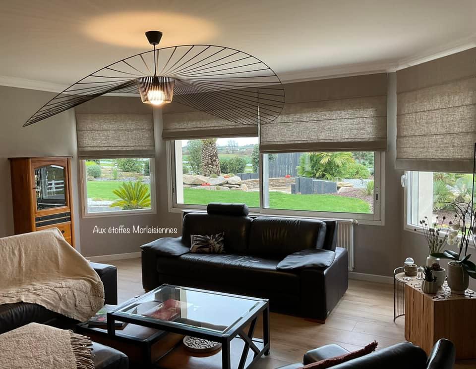 Stores bateaux gris dans un salon avec un canapé en cuir noir