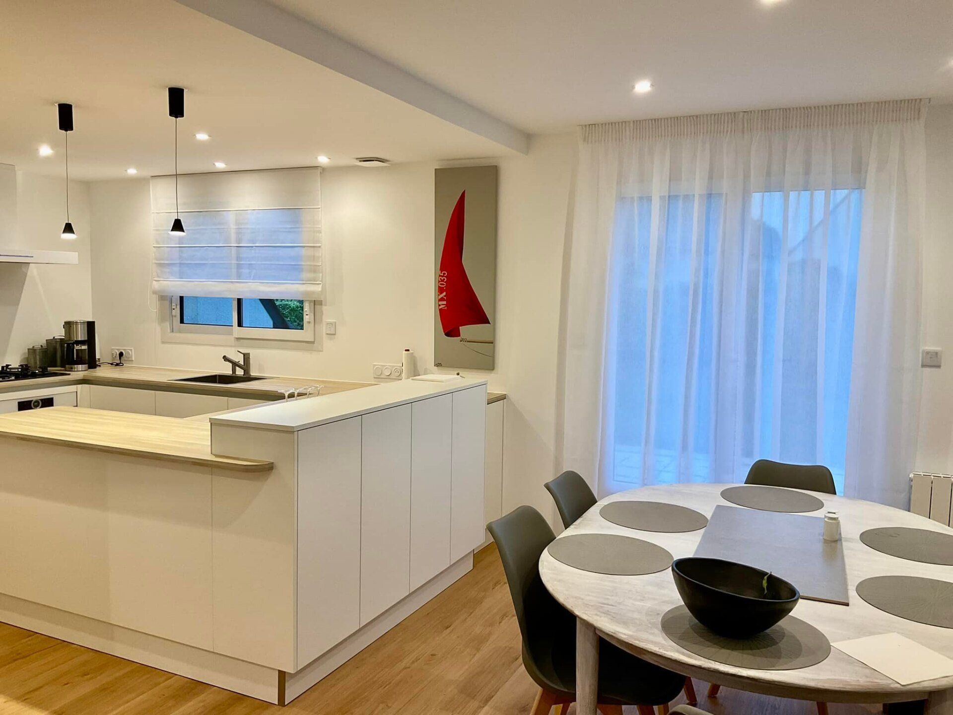 Store bateau blanc installé sur une fenêtre coulissante dans une cuisine