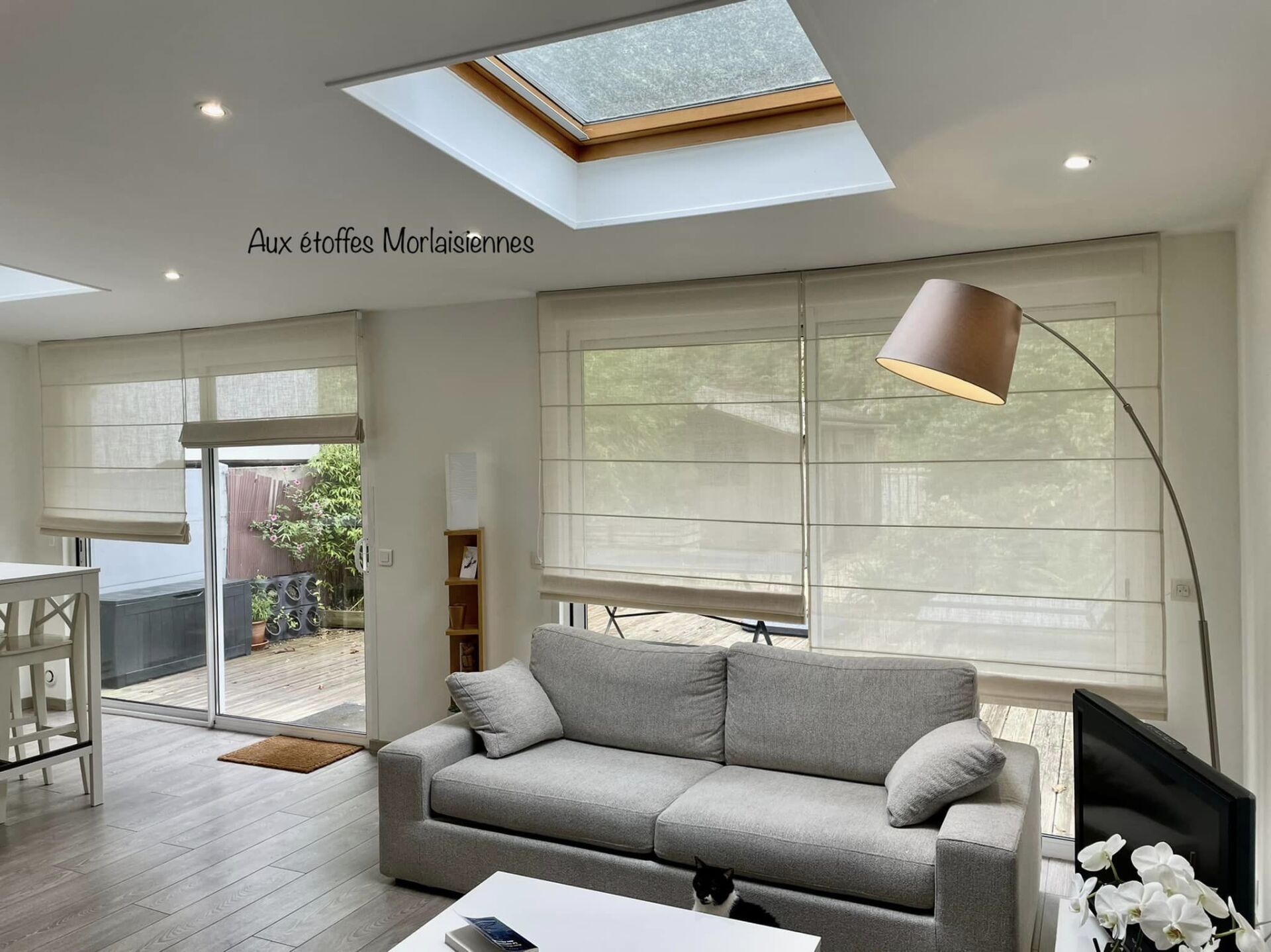 Stores bateaux blancs dans un salon majoritairement gris