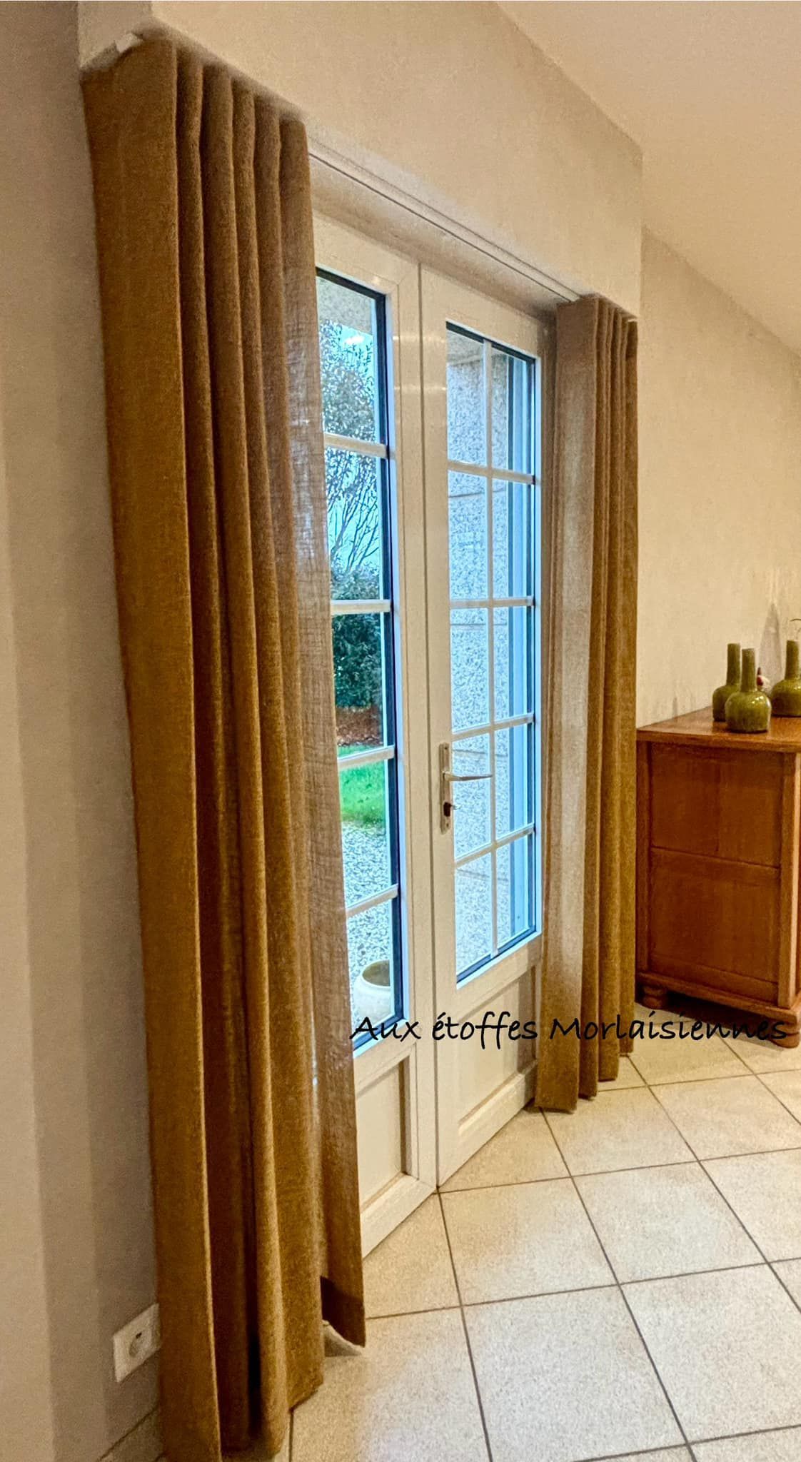 Voilages de couleur ocre installé pour une porte vitrée