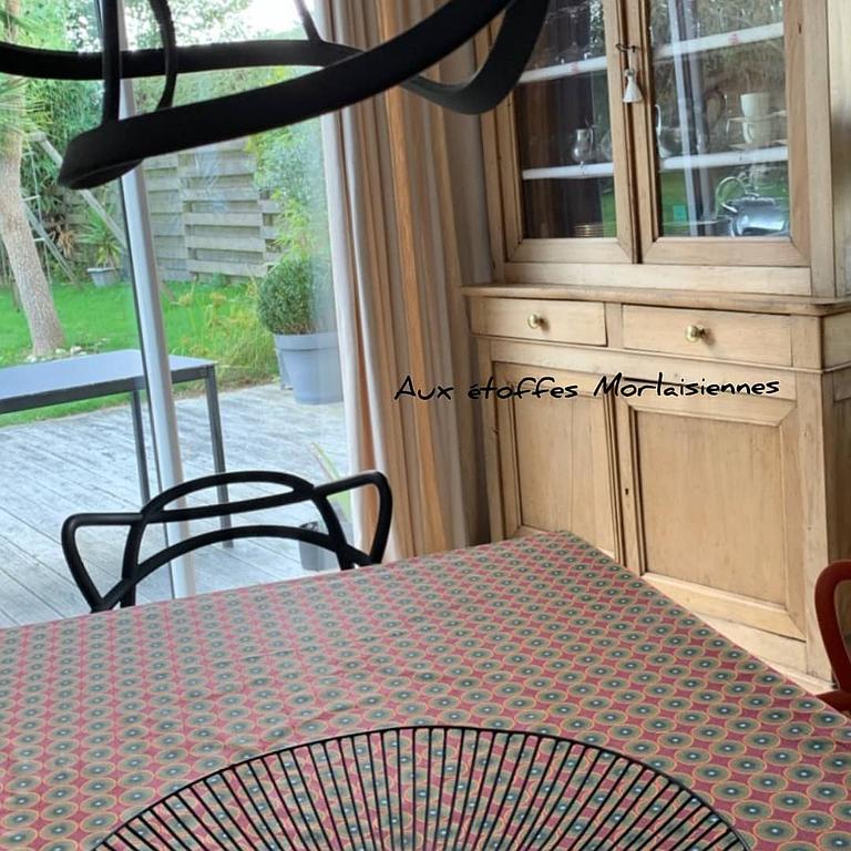 Store bateau bleu uni sur une fenêtre à côté de doubles rideaux occultant devant une porte-fenêtre