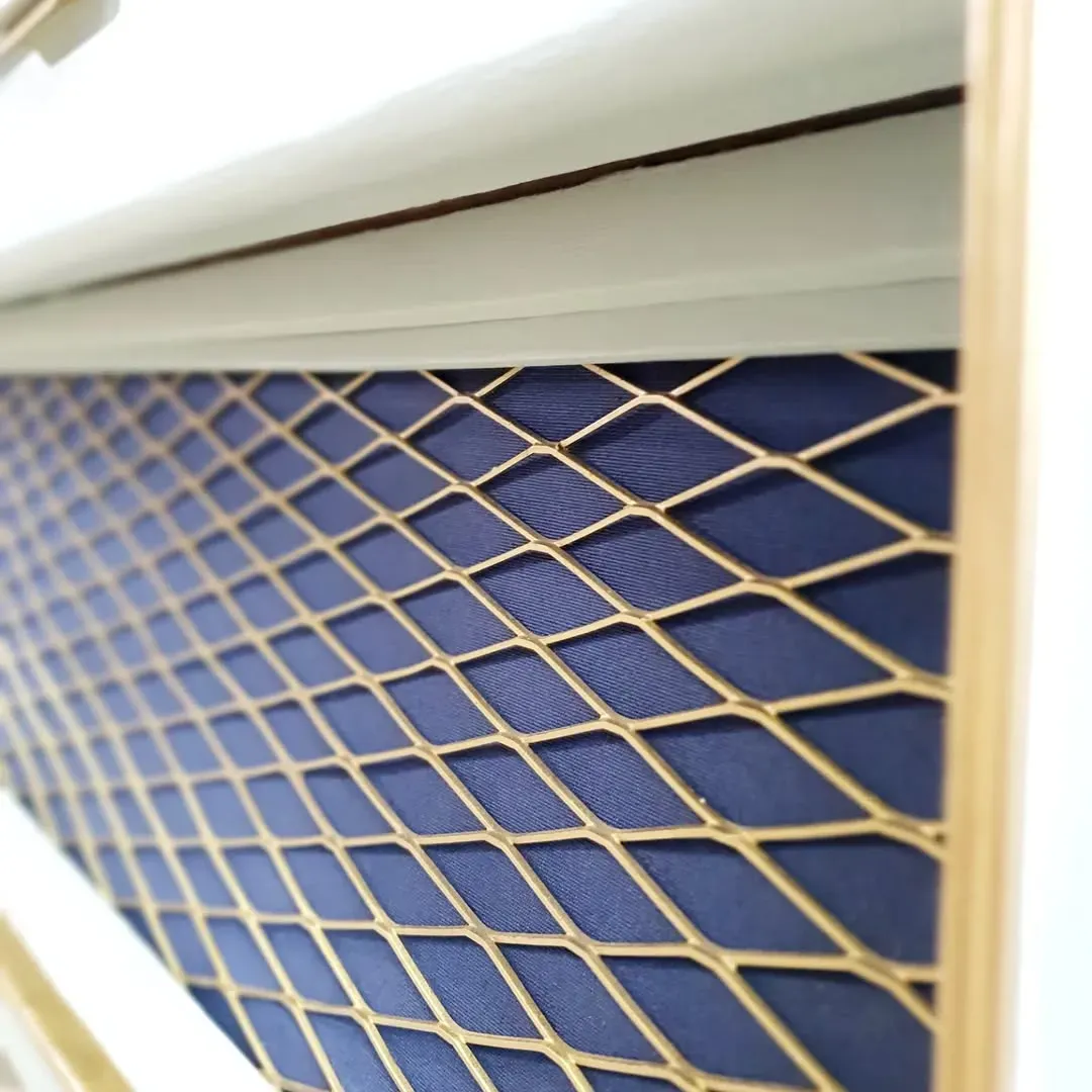 Malla metálica con diseño de diamantes dorados sobre tela azul, colocada en un marco blanco.