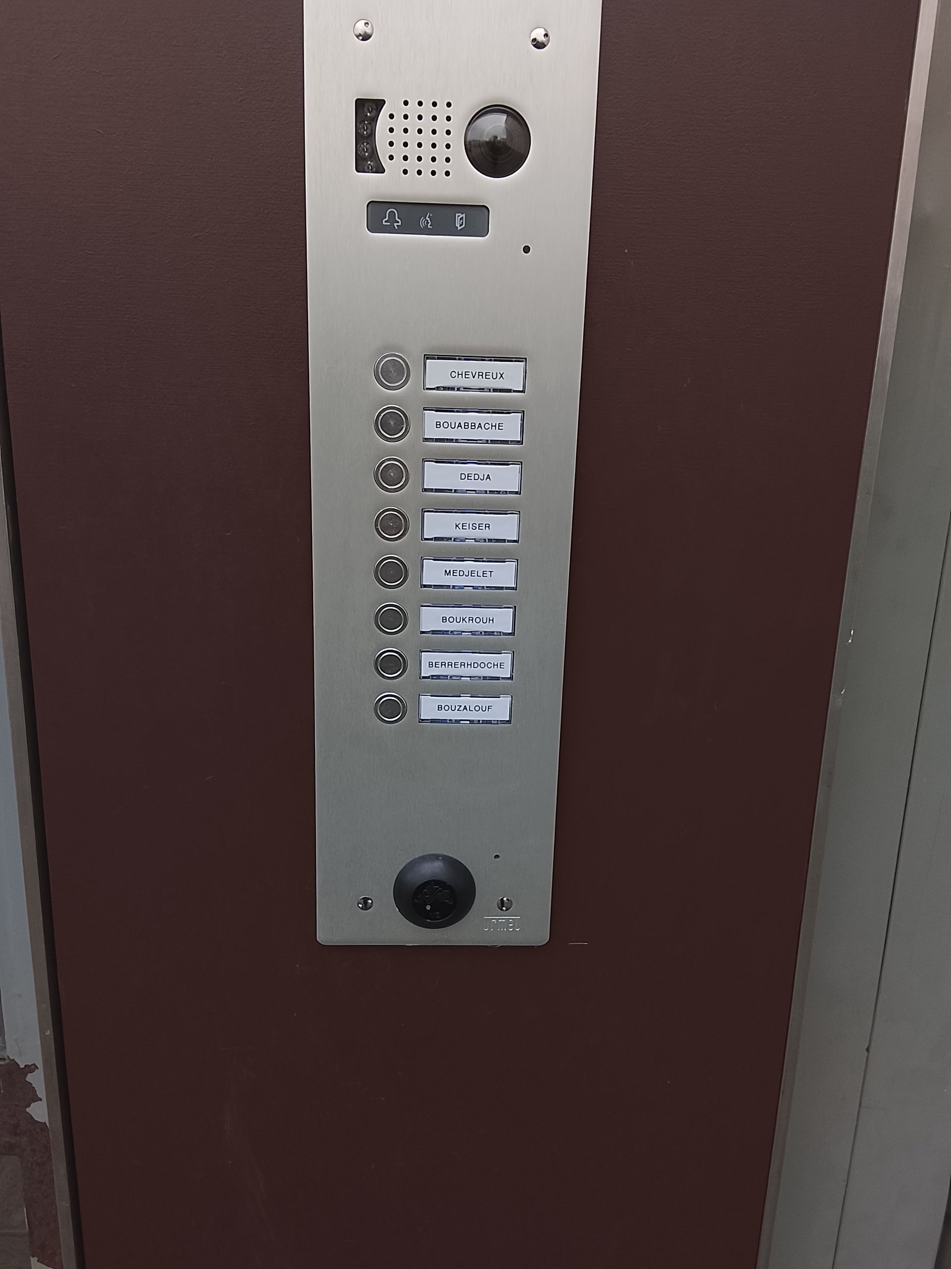 Un panneau d'accès mural gris à clavier numérique avec une grille de touches numériques et un lecteur RFID circulaire noir situé sous les touches.