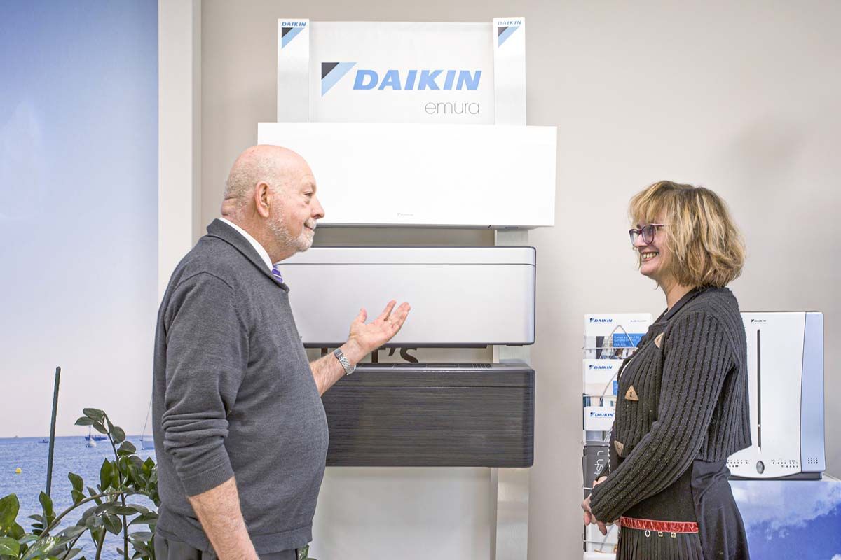 Commercial avec une employée devant des climatisations