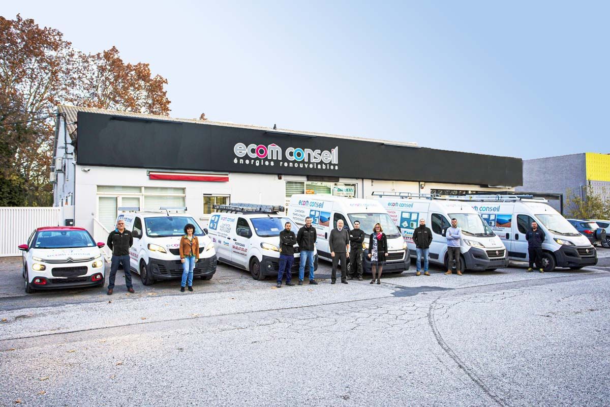 Équipe d'Ecom Conseil devant les véhicules et la devanture du magasin