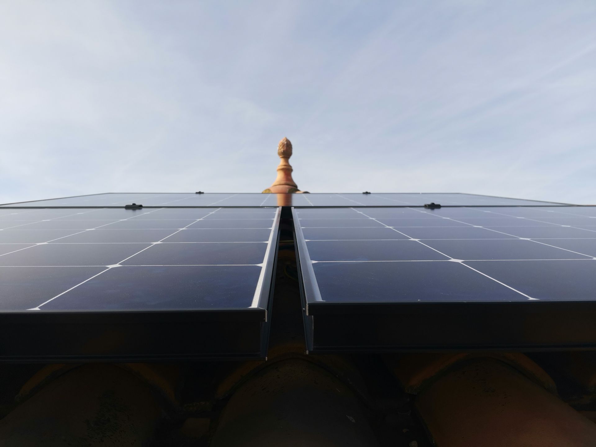 Panneau solaire sur un toit en tuile sous ciel nuageux