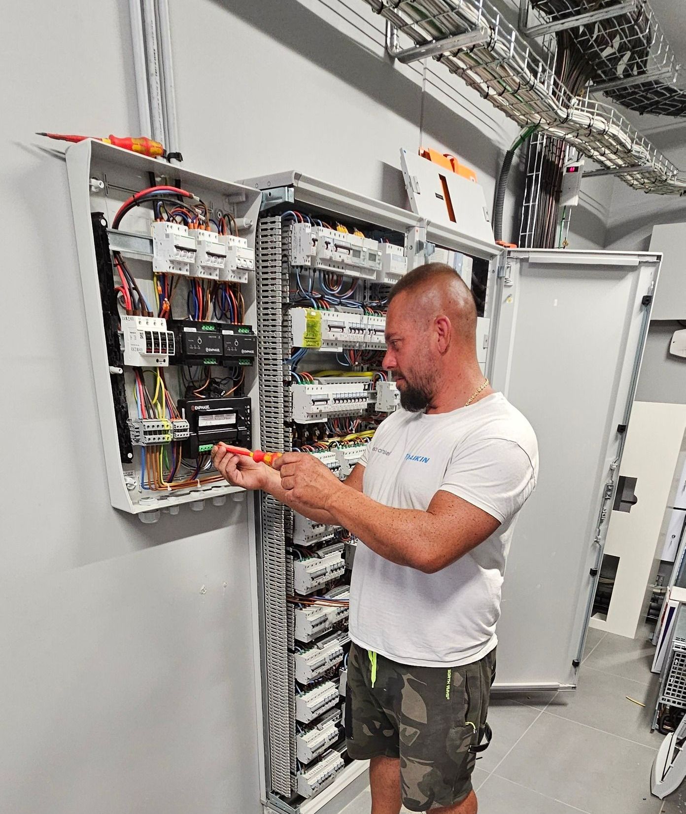 Ouvrier d'Ecom Conseil qui travaille dans un tableau électrique