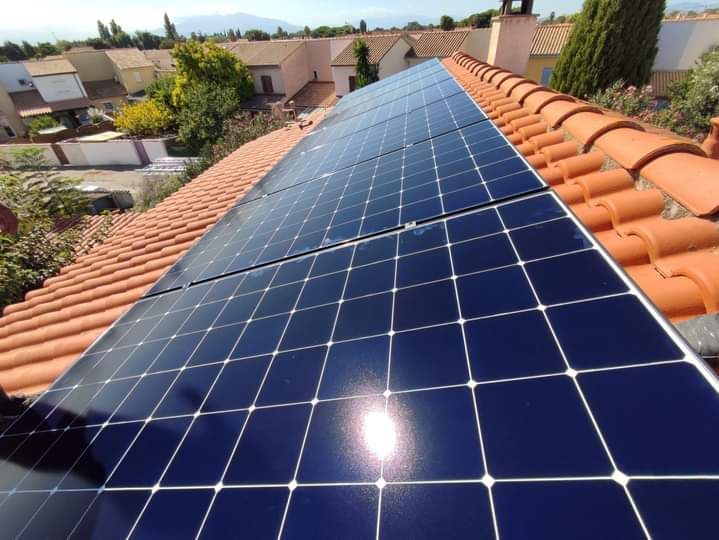 Panneau solaire sur un toit en tuile, avec reflet du soleil