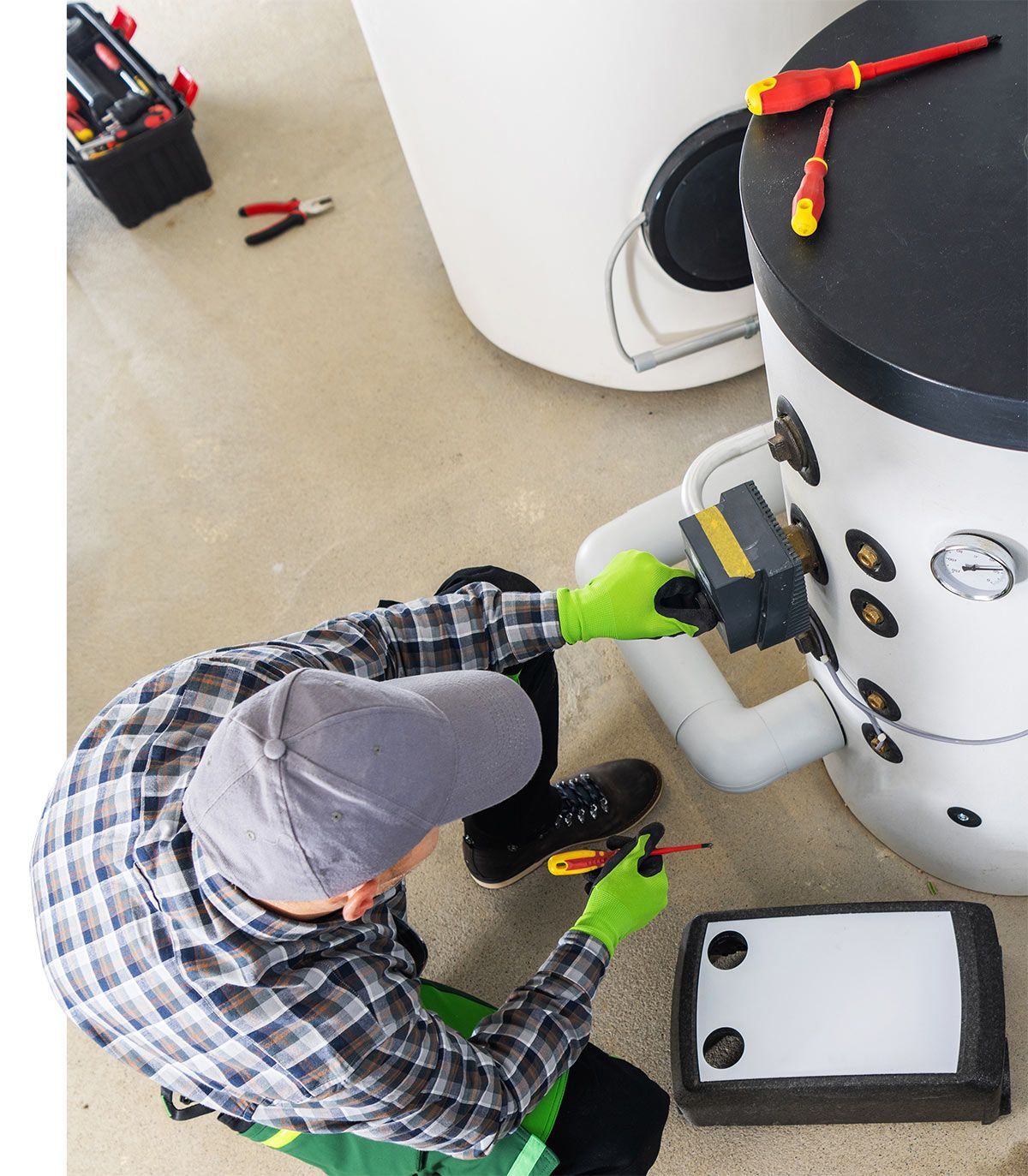 Technicien qui assure la maintenance d'un chauffe-eau