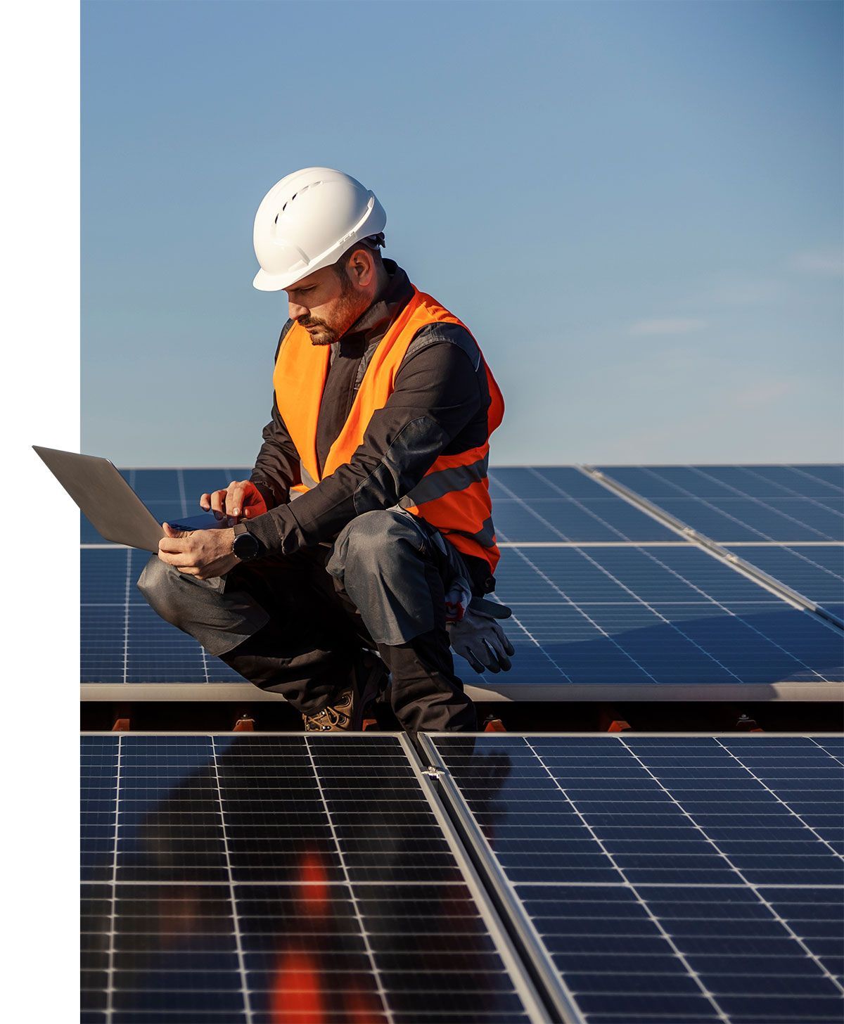 Technicien qui teste des panneaux solaires avec son ordinateur