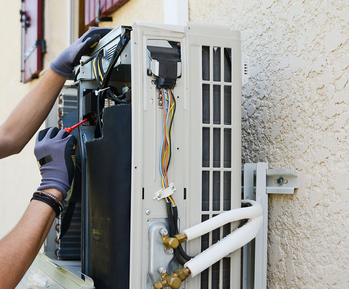 Zoom sur un ouvrier qui dépanne une pompe à chaleur