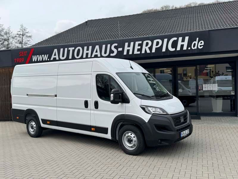 Weißer Fiat Ducato Transporter parkt vor dem Autohaus „Autohaus Herpich“.