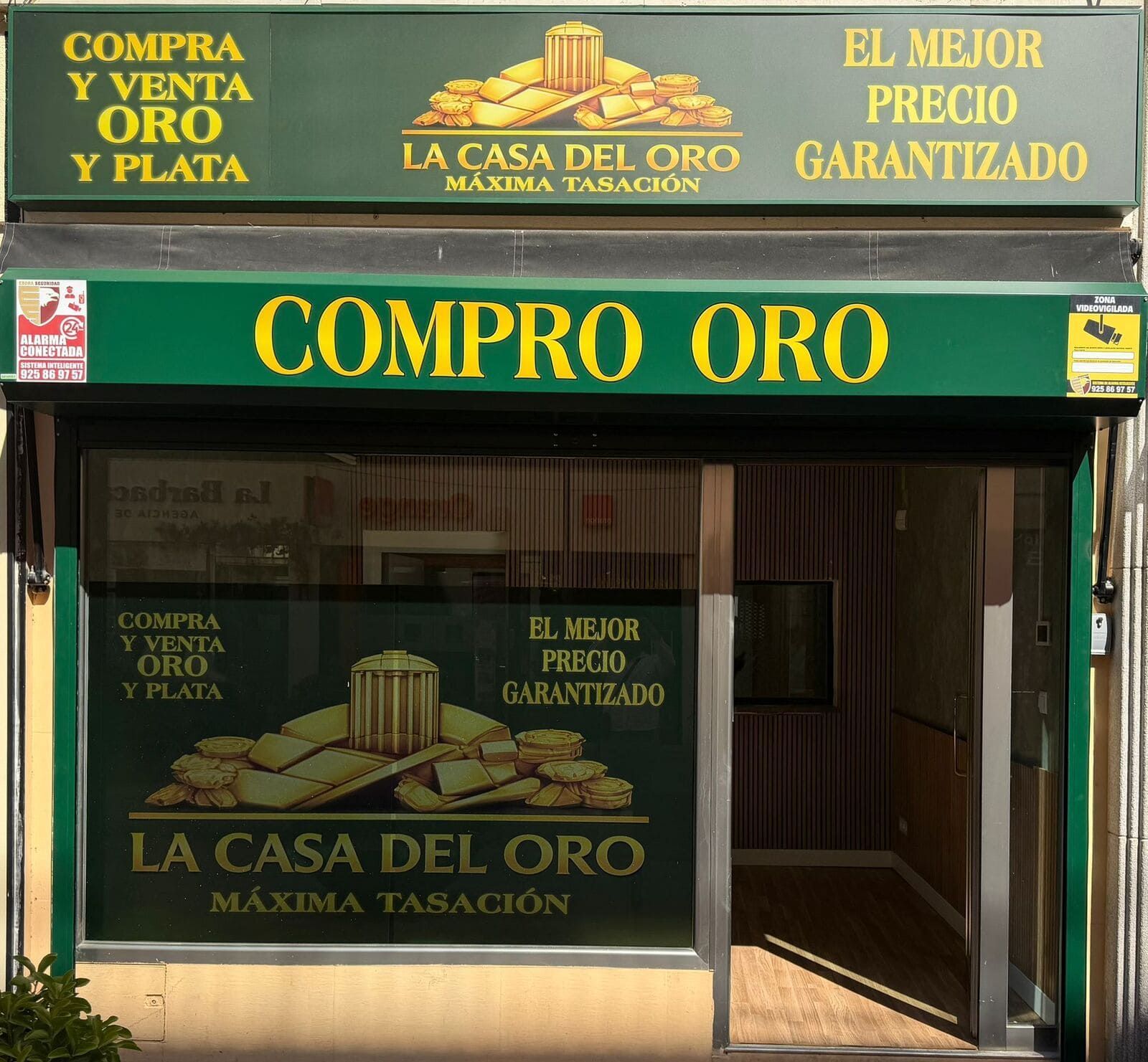 Fachada de “Compro Oro”, una tienda de compra de oro y plata con letreros verdes y dorados.