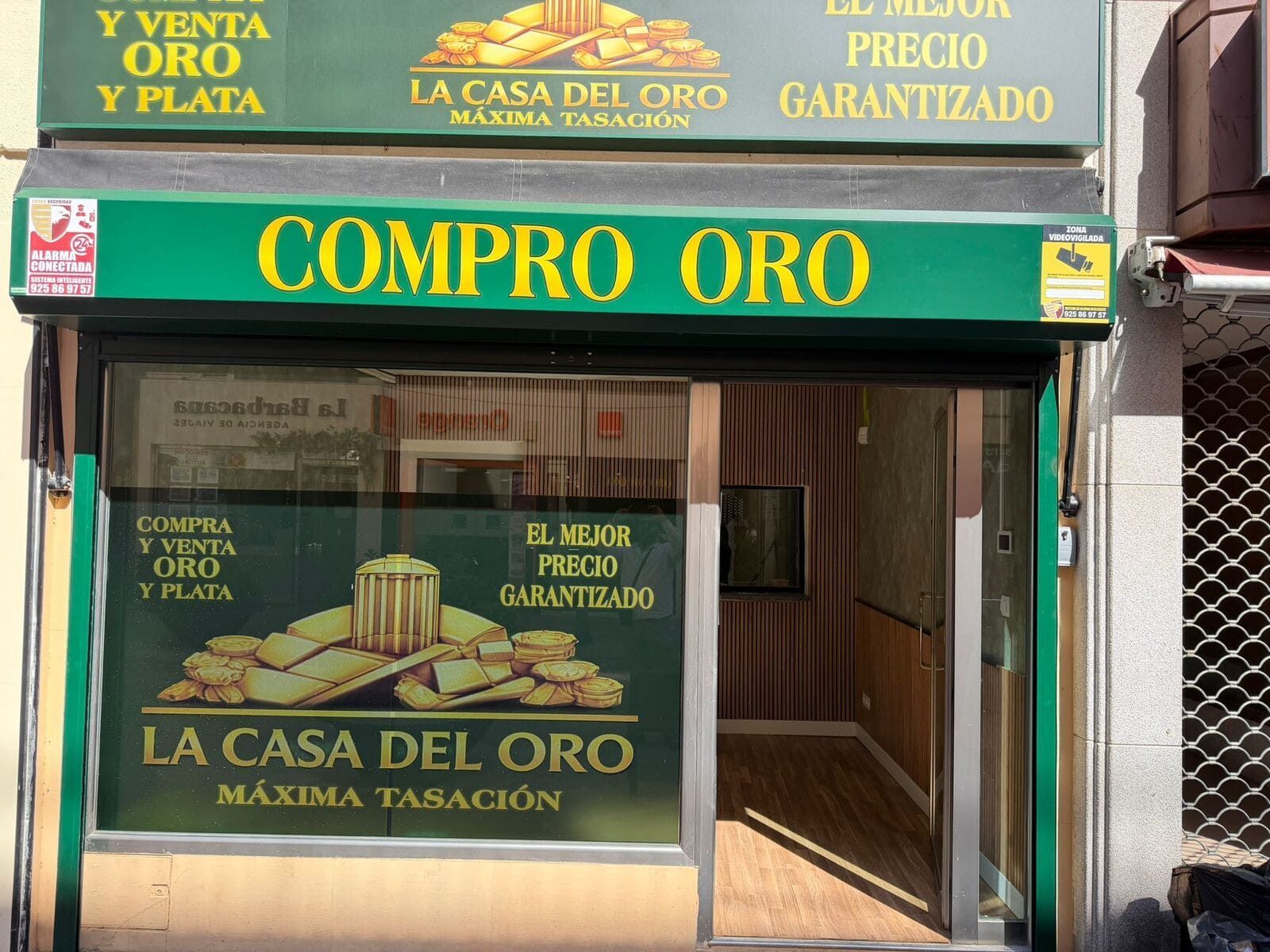 Fachada de “La Casa del Oro” con letreros verdes y dorados que anuncian la compra y venta de oro.