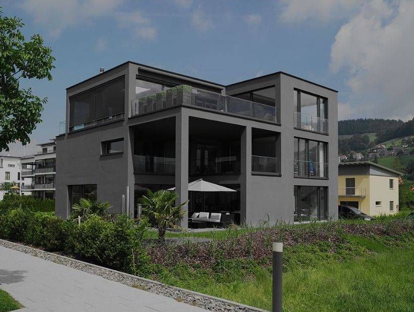 Ein großes graues Haus mit vielen Fenstern und Balkonen