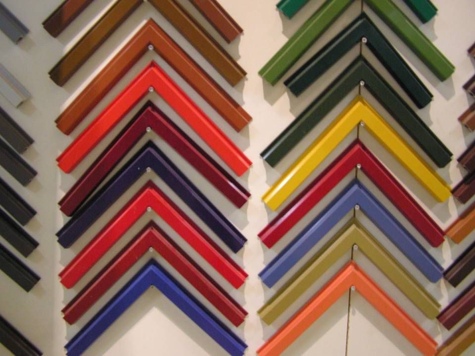 Viele verschiedenfarbige Fensterrahmen sind an einer Wand aufgereiht. Foto von der Adolf Nussbaumer Fensterbau AG