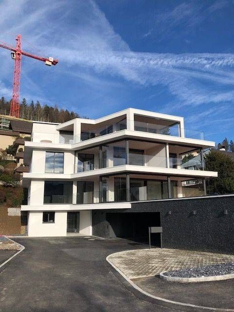 Ein grosses weisses Gebäude mit einem roten Kran im Hintergrund. Foto von der Adolf Nussbaumer Fensterbau AG
