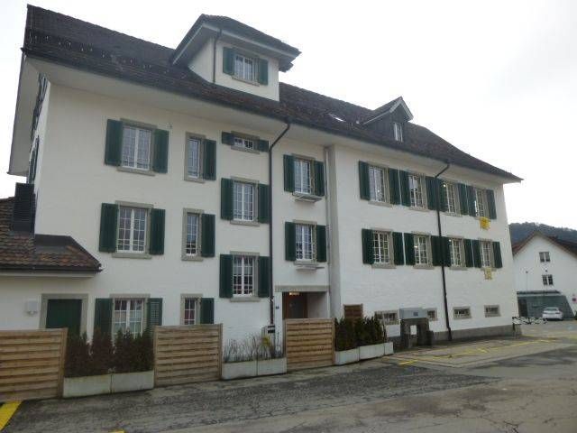 Ein großes weißes Gebäude mit grünen Fensterläden