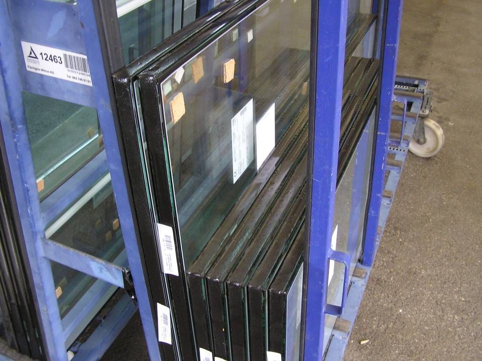 Ein Haufen Glasfenster sind übereinander gestapelt. Foto von der Adolf Nussbaumer Fensterbau AG
