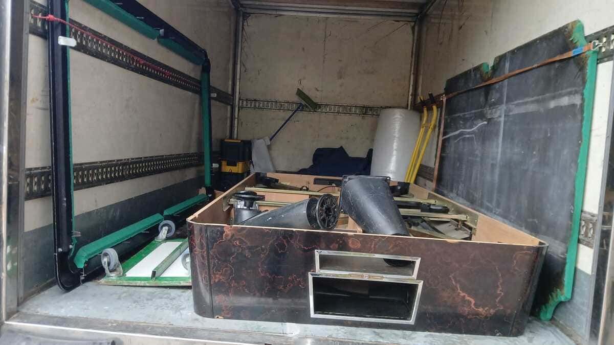 La parte trasera de un camión lleno de cajas y una plataforma rodante.