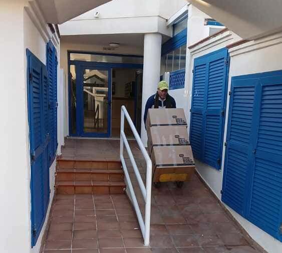 Un camión con cajas dentro está al lado de un mapa del mundo.