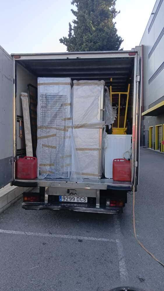 Dos hombres están cargando cajas en un camión de mudanzas.