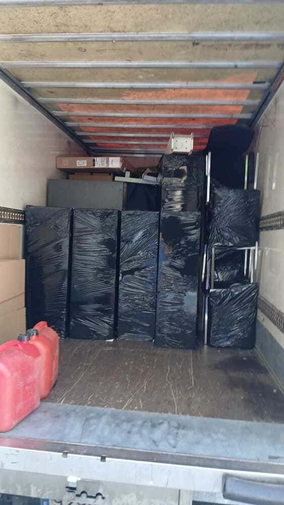 Dos hombres están cargando cajas en un camión de mudanzas.