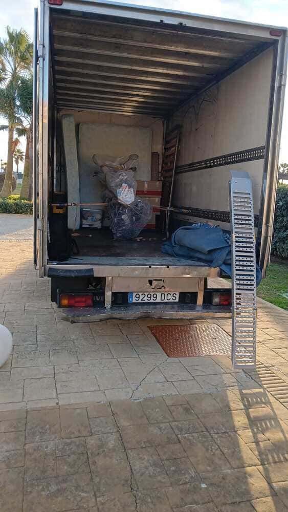 Dos hombres están cargando cajas en un camión de mudanzas.