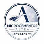 Logotipo de Microcemento Altea con icono de paleta y número de teléfono en una insignia circular azul y blanca.